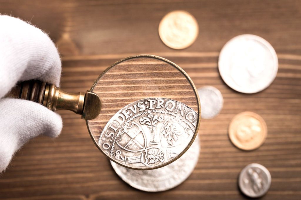 looking at old silver coin through magnifying glass