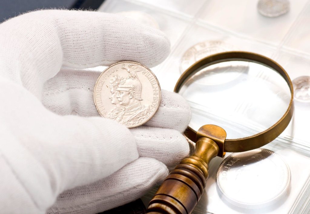 old silver coin and magnifying glass