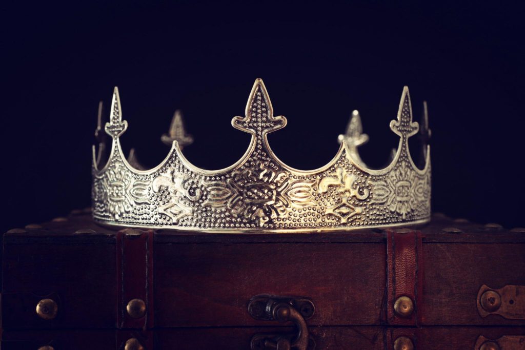 silver crown atop wooden chest