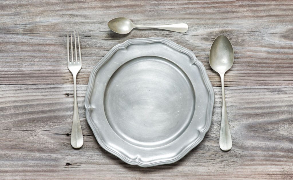 spoons and pewter plate on old wooden boards
