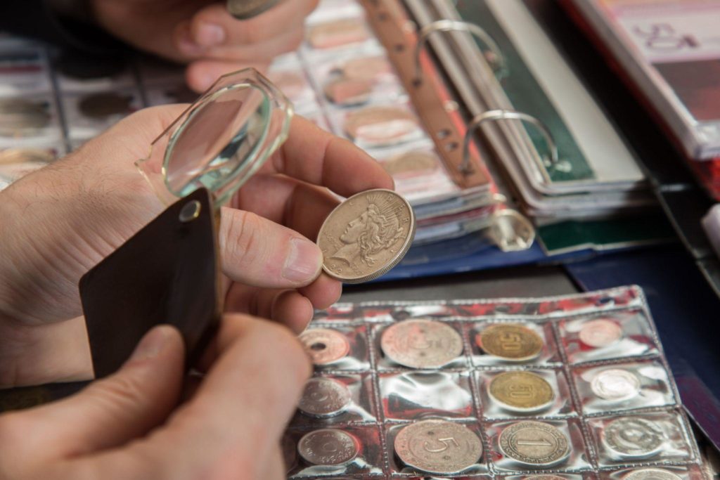 numismatists examines collection of coin