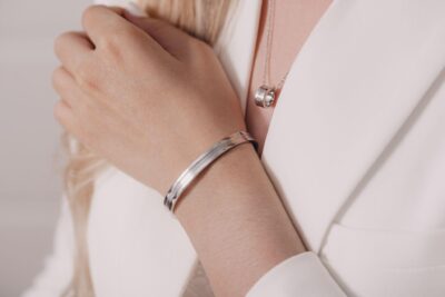 Woman wearing elegant pendant necklace and bracelet.