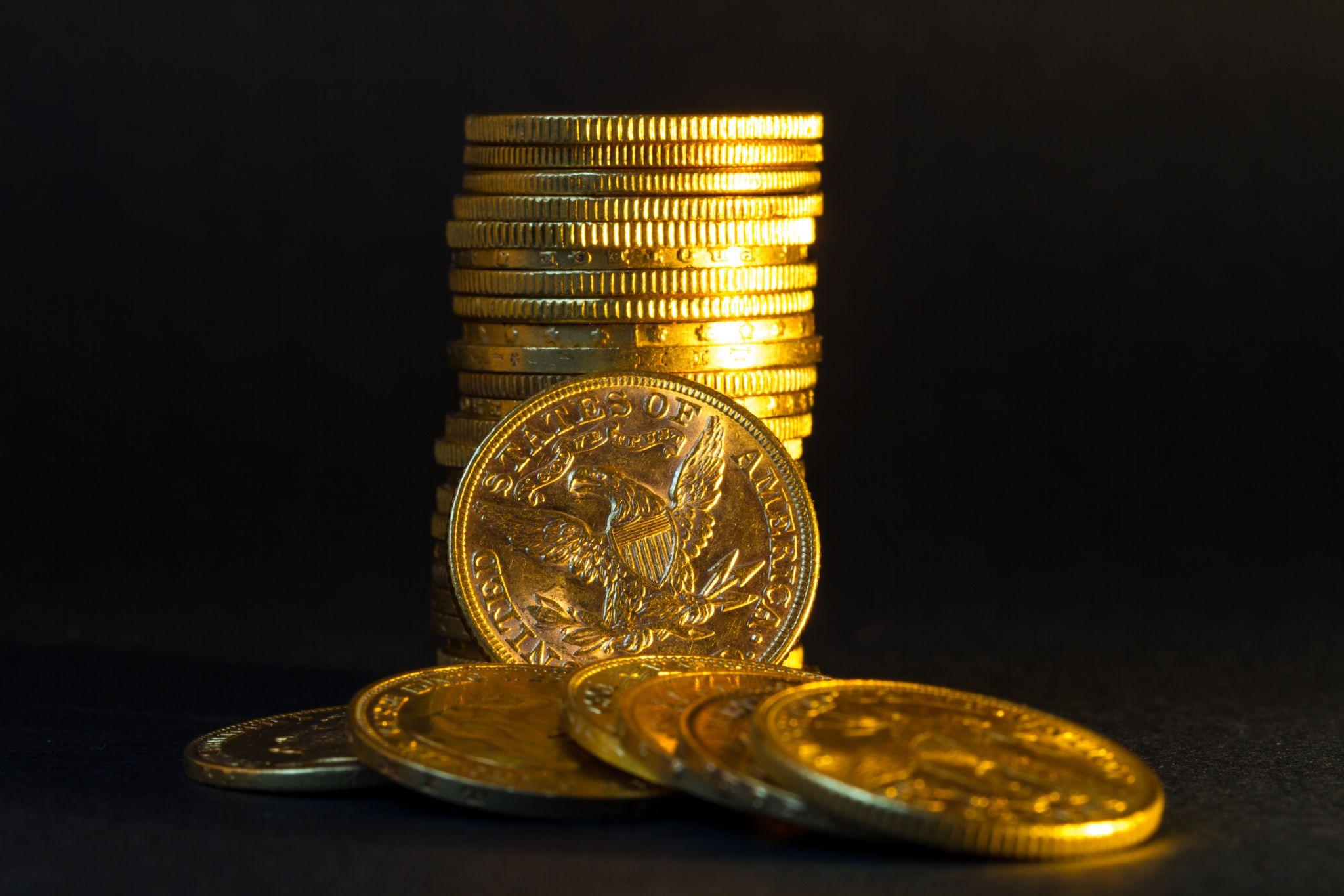 Stack of gold coins on black background.
