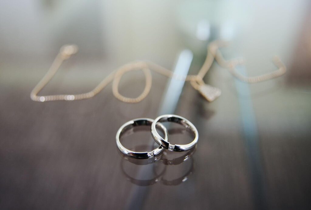 Wedding rings of white gold with the words love on background.